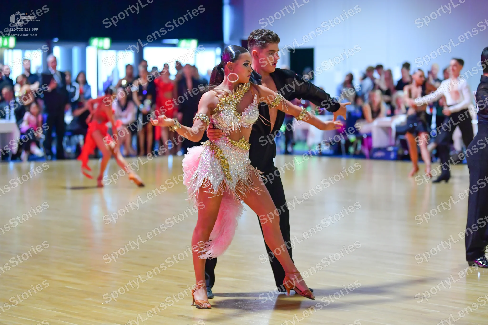 Dancesport competitor: Main female dancer: cream Latin dress with gold sequin and beadwork, featuring w