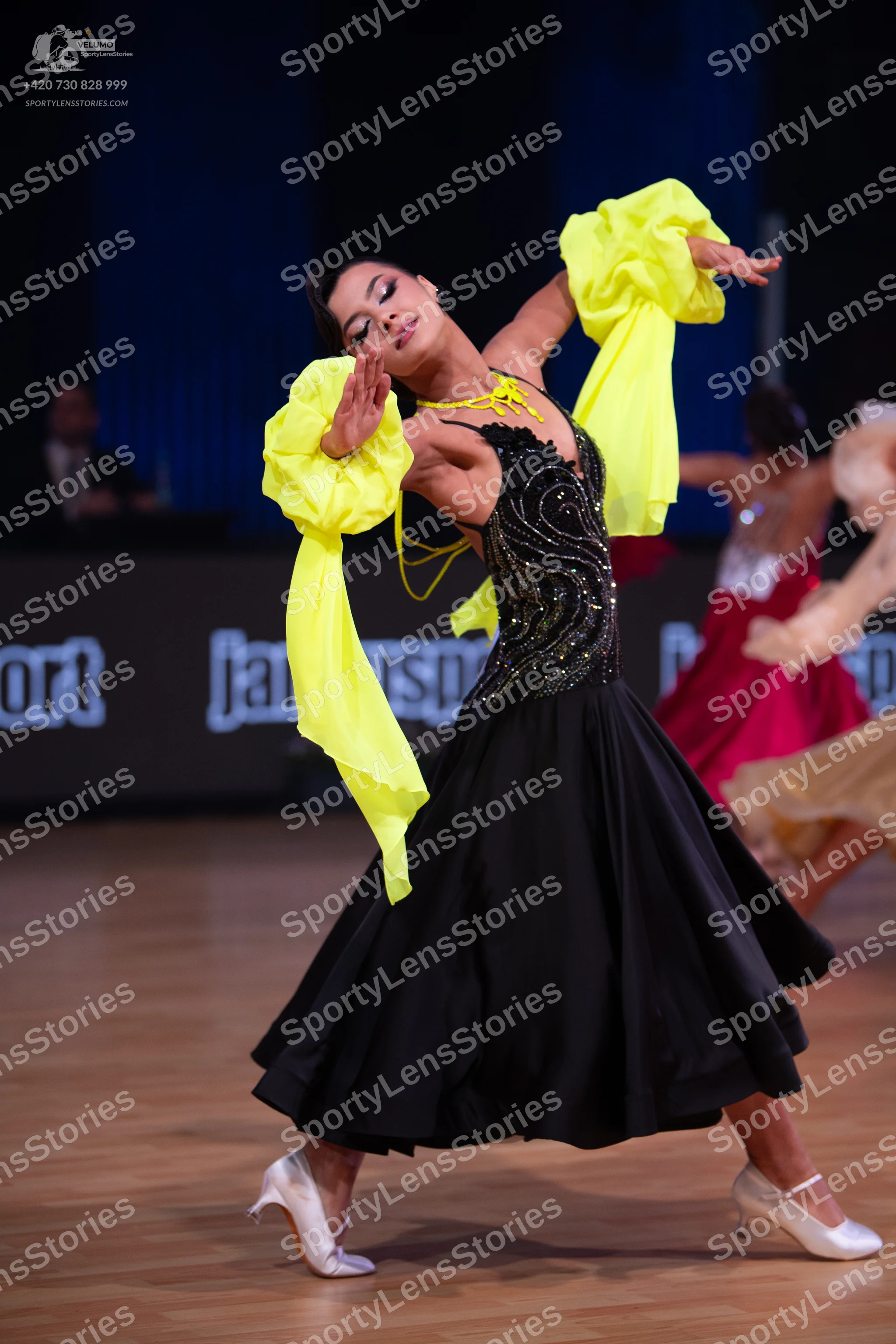 Dancesport competitor: Female dancer: black ballgown with a black sequined bodice in a swirling pattern