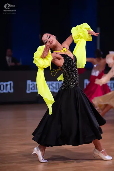 Dancesport competitor: Female dancer: black ballgown with a black sequined bodice in a swirling pattern