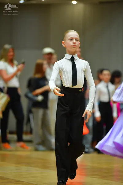 Dancesport competitor: Main male dancer: white long-sleeved shirt, black necktie, and black trousers