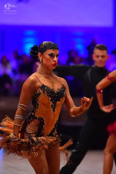 Dancesport competitor: Female dancer: tan/nude Latin dance dress with black sequin and lace embroidery 