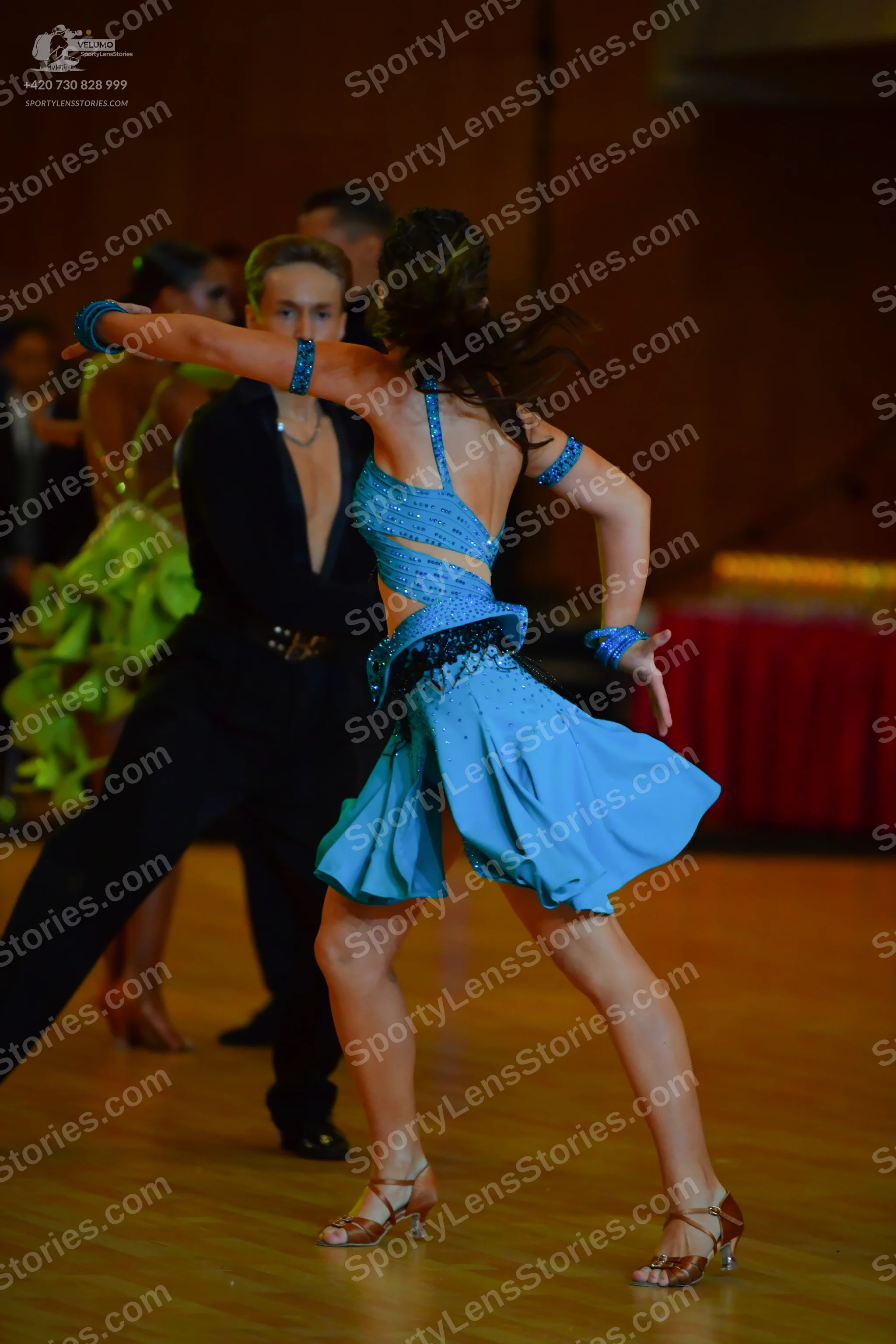 Dancesport competitor: Female dancer: light blue latin dress with cutouts and dark sequined embellishme