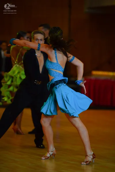 Dancesport competitor: Female dancer: light blue latin dress with cutouts and dark sequined embellishme