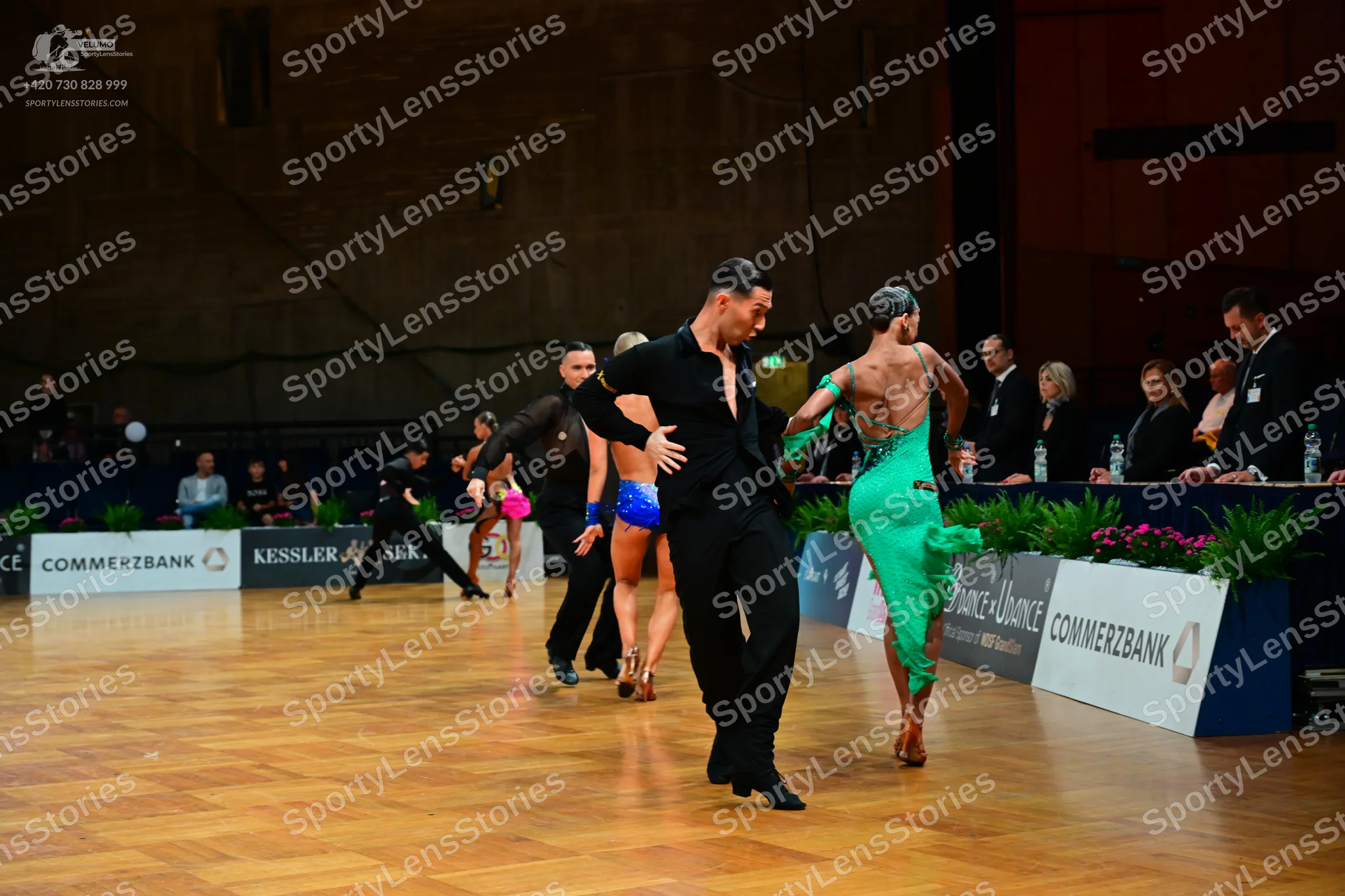 Dancesport competitor: Male dancer (foreground): black long-sleeved shirt and black trousers