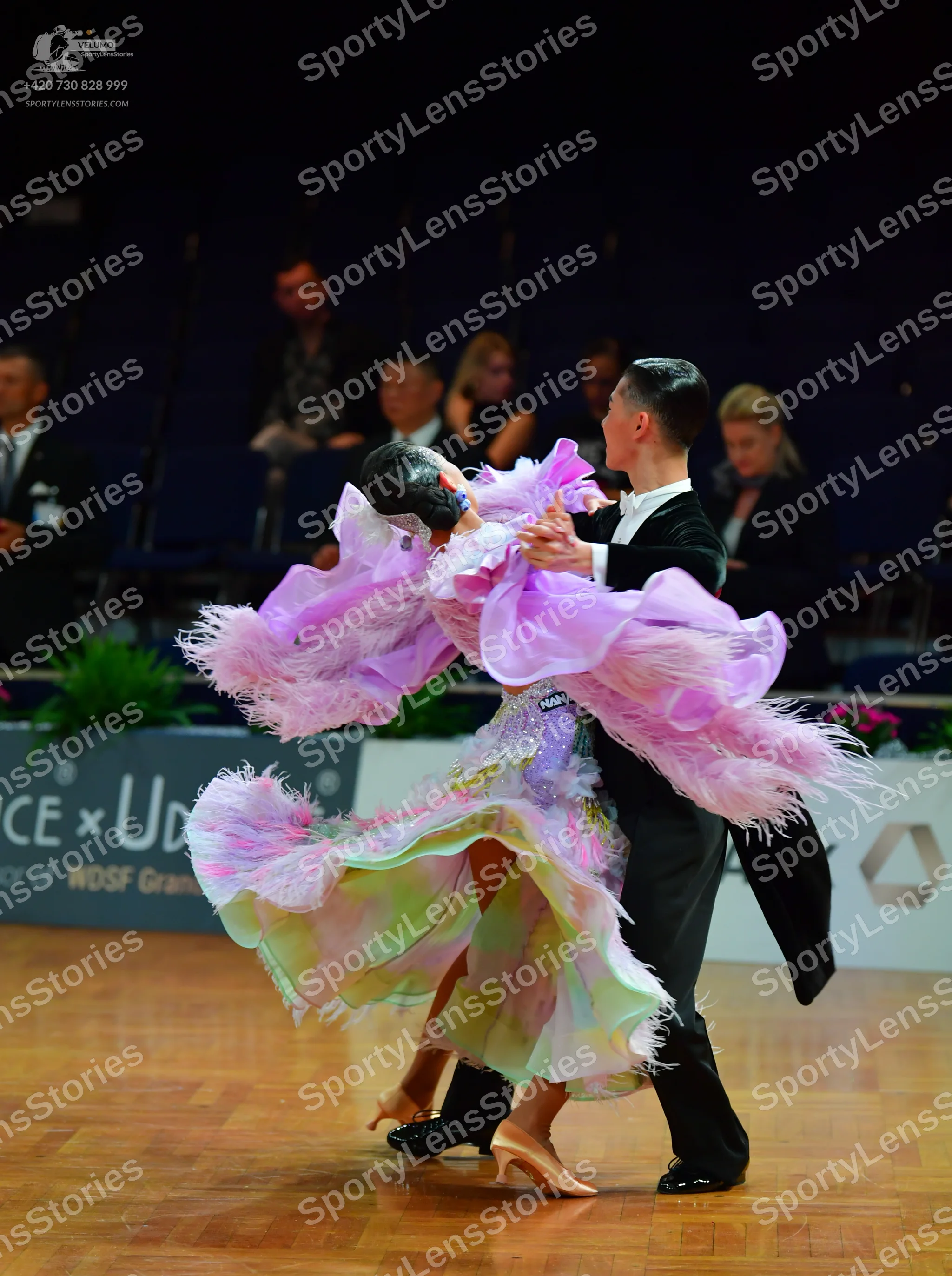 Dancesport competitor: Female dancer: voluminous lilac ballroom gown featuring a feathery, ruffled neck