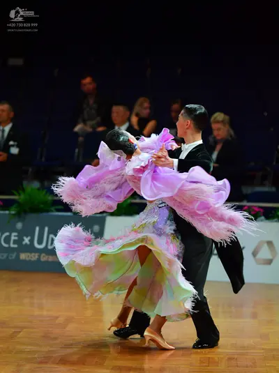 Dancesport competitor: Female dancer: voluminous lilac ballroom gown featuring a feathery, ruffled neck