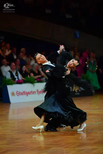 Dancesport competitor: Male dancer: black long-sleeved shirt with a white collar and black trousers