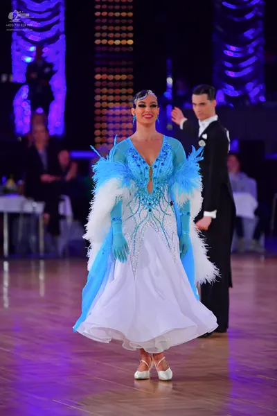 Dancesport competitor: Female dancer: light blue and white ballgown with crystal embellishments, deep V