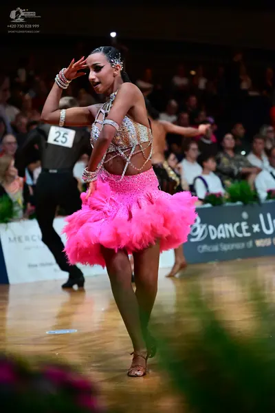 Dancesport competitor #25: Female dancer: pink latin dress with a sequined/beaded halter-style top and a ve