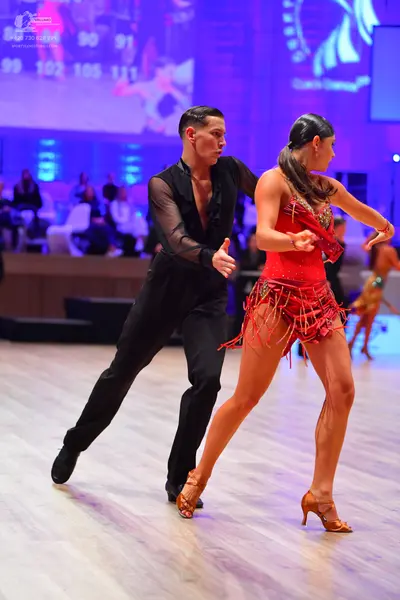 Dancesport competitor: Male dancer: black shirt with sheer sleeves and black trousers