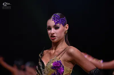 Dancesport competitor: Female dancer: gold/champagne Latin dance top with sequins and embellishments, f