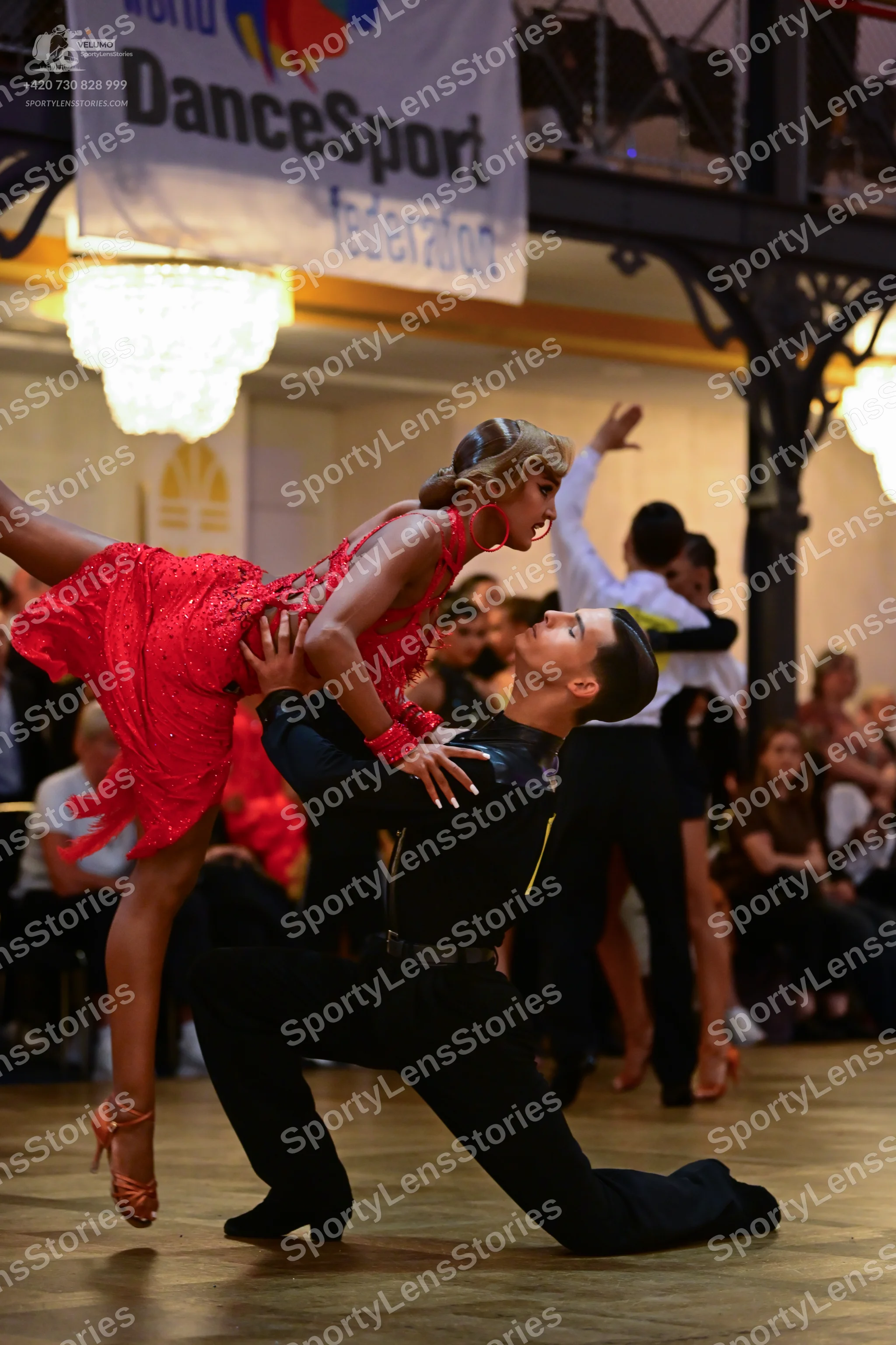 Dancesport competitor: Female dancer: red sequined Latin dress with thin straps