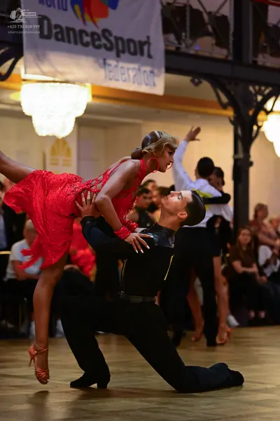 Dancesport competitor: Female dancer: red sequined Latin dress with thin straps