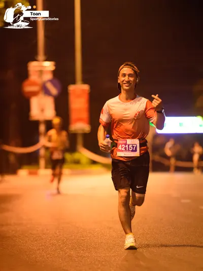 Marathon runner #42157: Runner 1: light gray jersey with red sleeves, black shorts, white shoes, a black