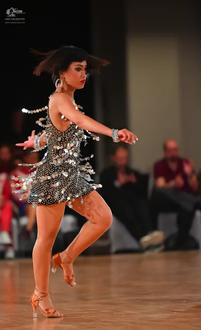 Dancesport competitor: Female dancer: short black latin dress embellished with large silver sequins/dis