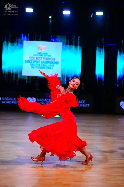Dancesport competitor: Female dancer: red ballroom dress with voluminous ruffled skirt and sleeves