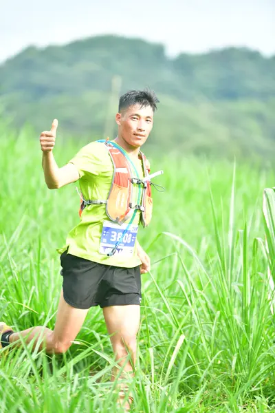 Marathon runner #30: Runner 1: lime green jersey, black shorts, hydration vest, black watch