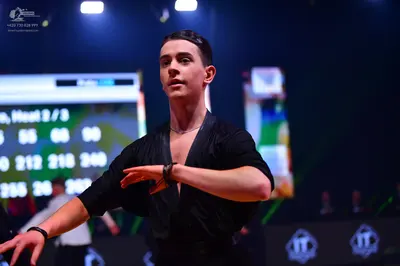 Dancesport competitor: Male dancer (foreground): black shirt with a deep V-neck