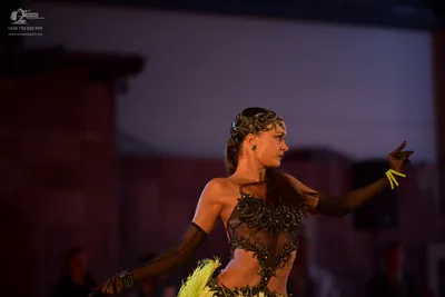 Dancesport competitor: Female dancer: black Latin dance costume with intricate dark embroidery/beading,