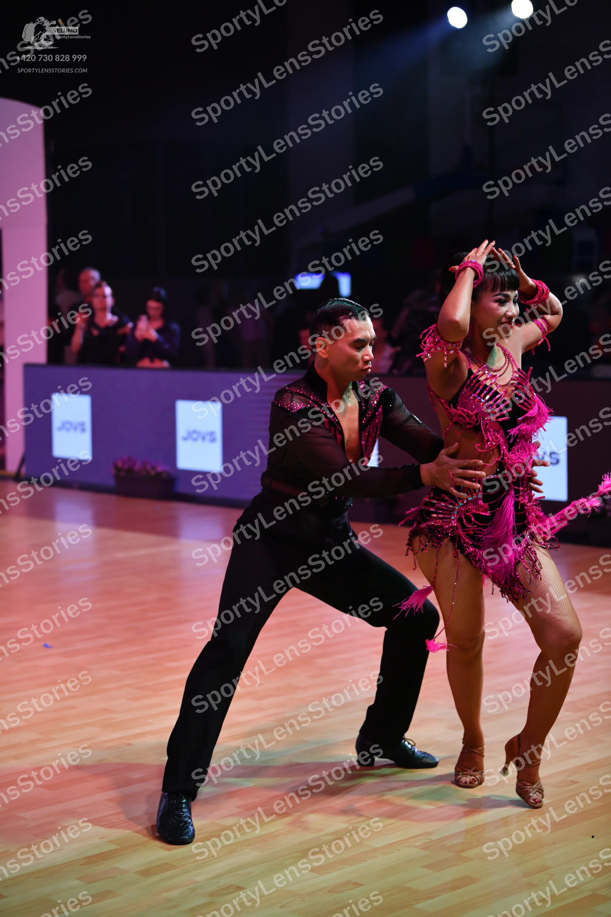 Dancesport competitor: Male dancer: black long-sleeved shirt with pink sequin detailing and black trous