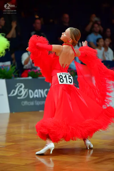 Dancesport competitor #815: Female dancer: red Latin dress with feathers and an open back