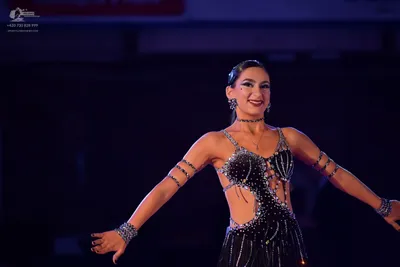 Dancesport competitor: Female dancer: black Latin dance dress with silver sequins and rhinestones, feat