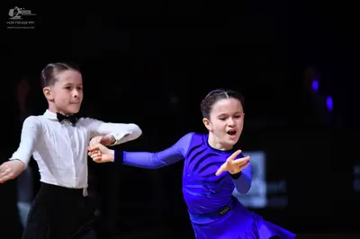 Dancesport competitor: Male dancer: white long-sleeved shirt, black bow tie, and black trousers