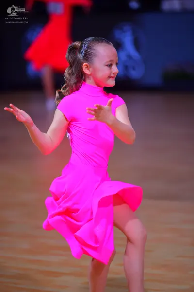 Dancesport competitor: Female dancer: bright pink, short-sleeved Latin dress