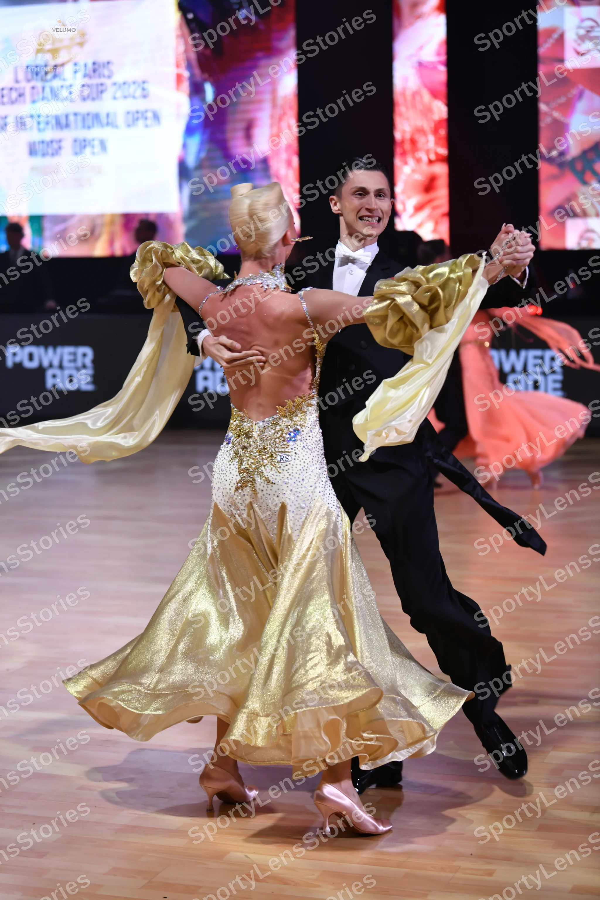 Dancesport competitor: Female dancer: gold and white ballroom gown with a white sequined bodice and a v