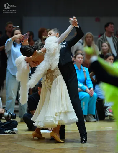 Dancesport competitor: Female dancer: cream-colored ballroom dress with an intricate lace bodice and a 