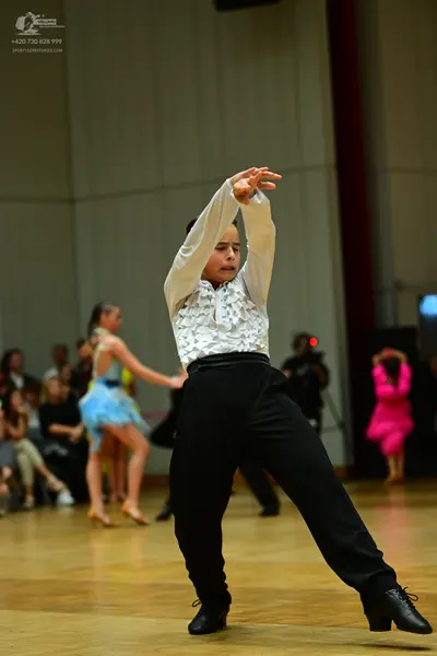 Dancesport competitor: Male dancer: white long-sleeved shirt with ruffled chest and black trousers