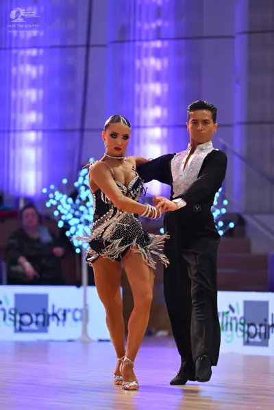 Dancesport competitor: Male dancer: black long-sleeved shirt with a white sequined front panel and blac