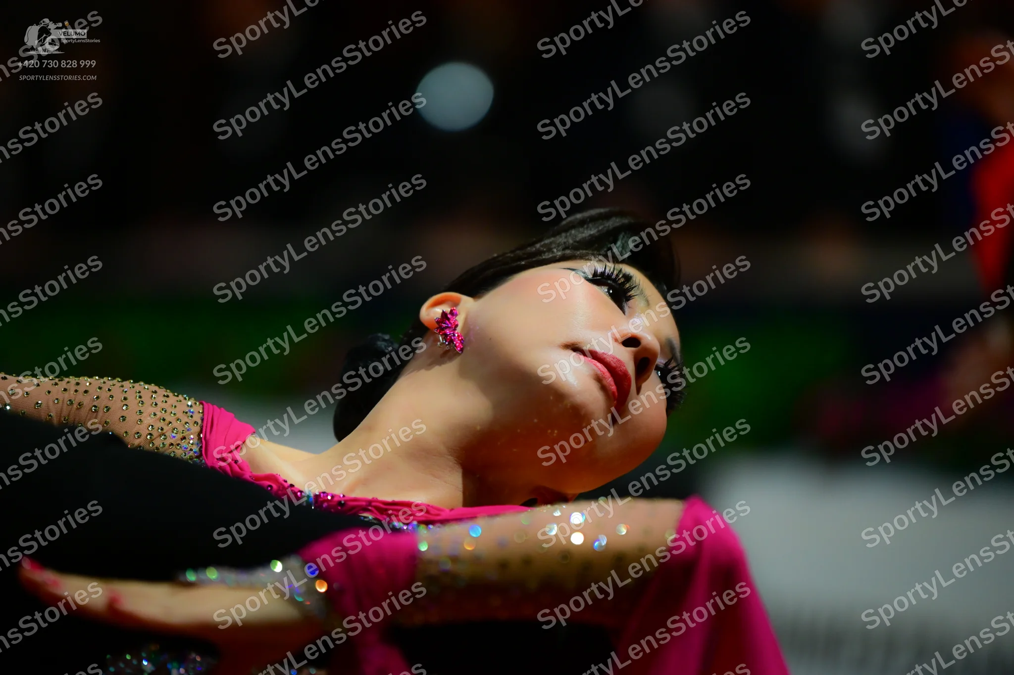 Dancesport competitor: Female dancer: bright pink/magenta Latin dance dress with sheer, nude-toned slee