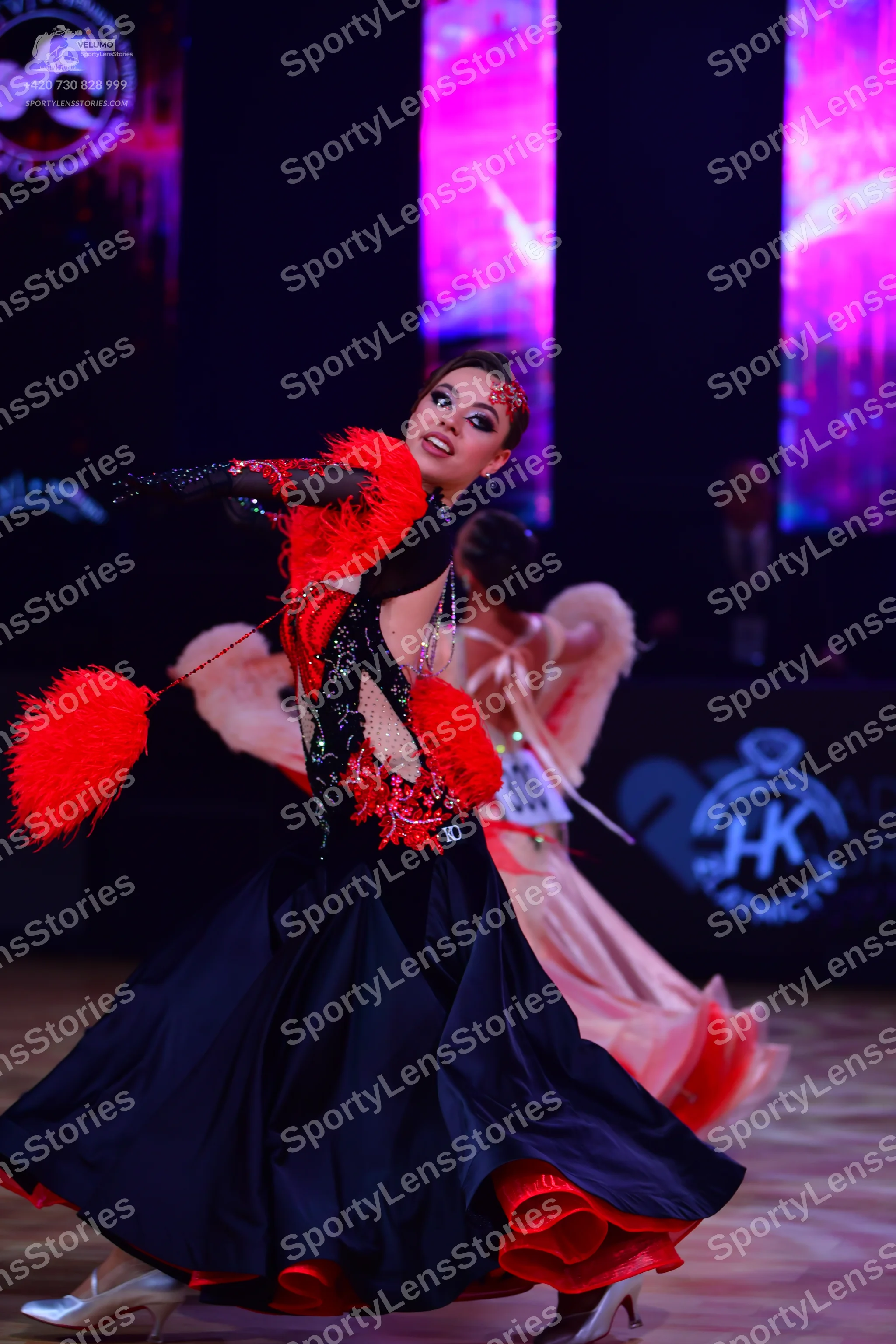 Dancesport competitor: Female dancer (front): black and red ballgown with a sequined bodice, large red