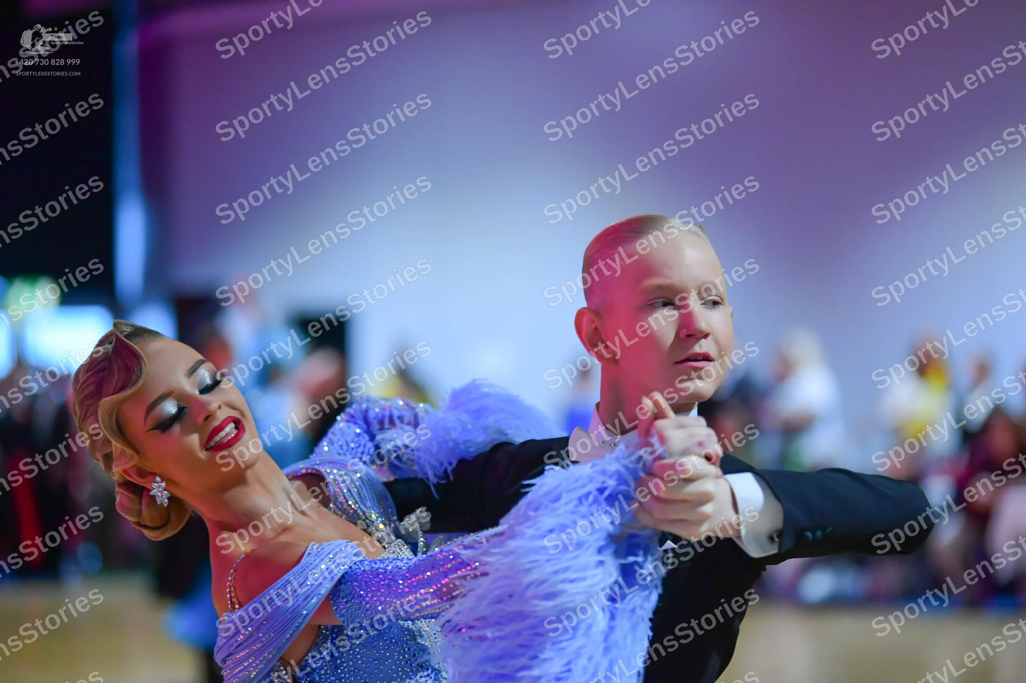 Dancesport competitor: Female dancer: light blue sequined dress with large light blue feather/fringe de