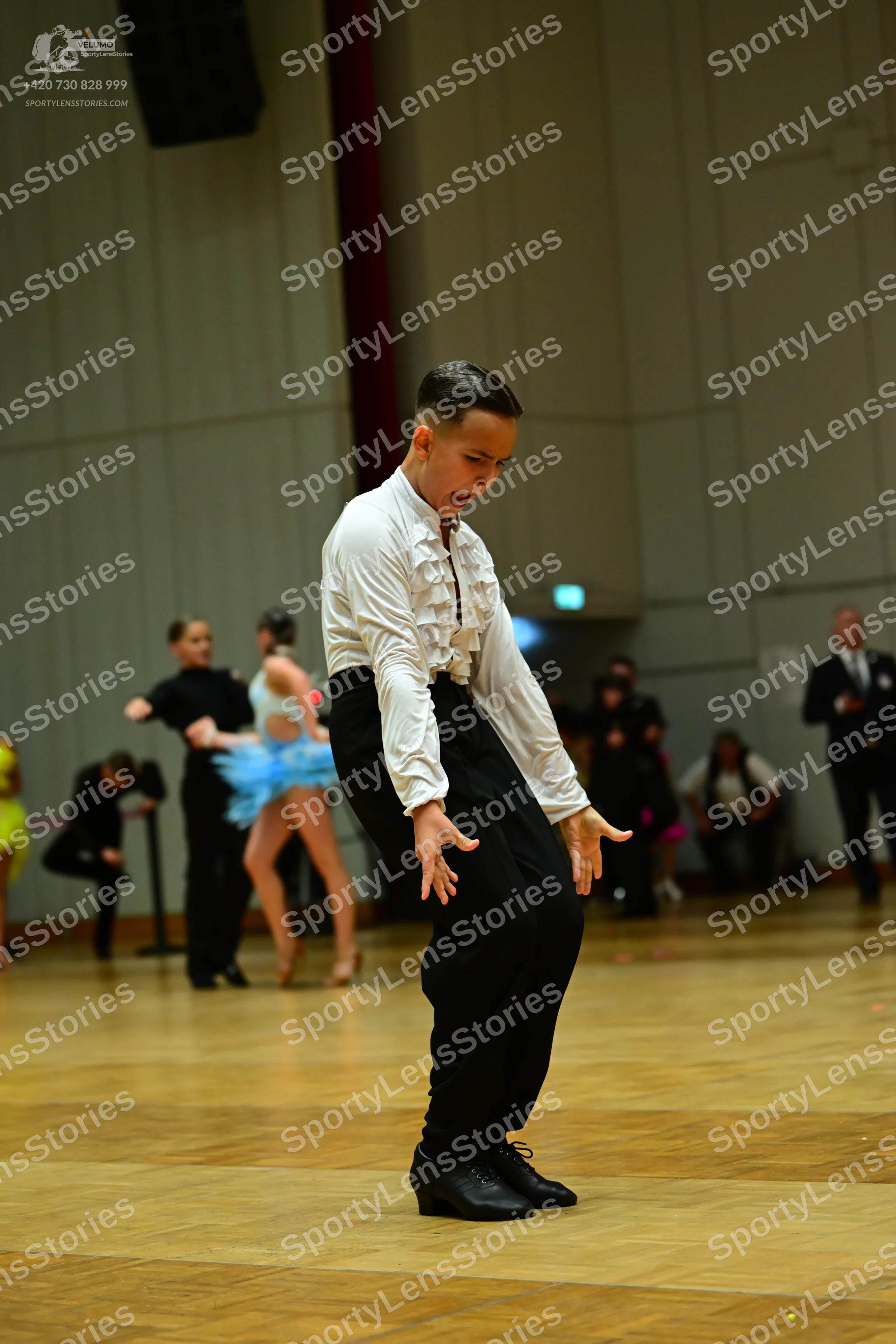 Dancesport competitor: Male dancer: white long-sleeved shirt with ruffles on the front and black trouse
