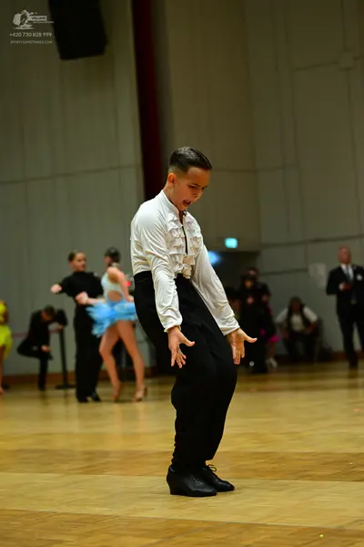 Dancesport competitor: Male dancer: white long-sleeved shirt with ruffles on the front and black trouse