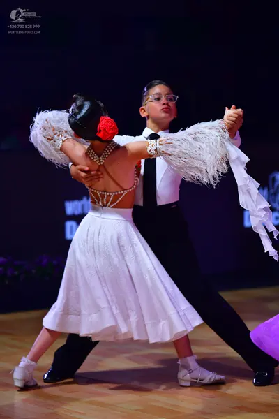 Dancesport competitor: Male dancer: white long-sleeved shirt, black tie, and black trousers