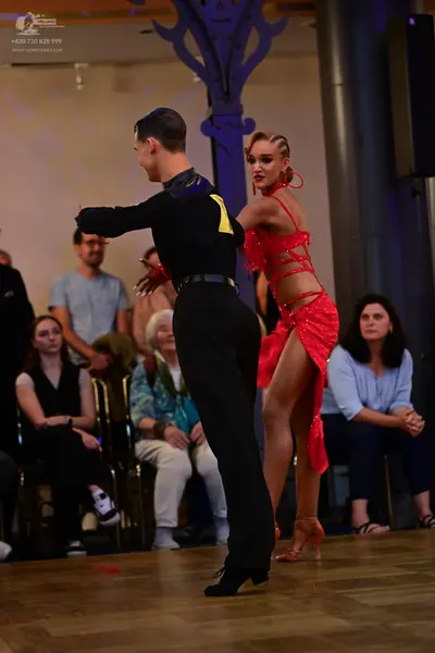 Dancesport competitor: Male dancer: black long-sleeved shirt with yellow detail on the back, black trou