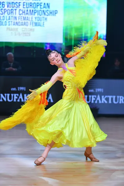 Dancesport competitor: Female dancer: bright yellow latin dress with a voluminous skirt and large, yell