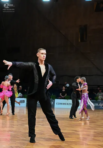 Dancesport competitor: Main male dancer: black suit with satin-like lapels, worn with an open black shi