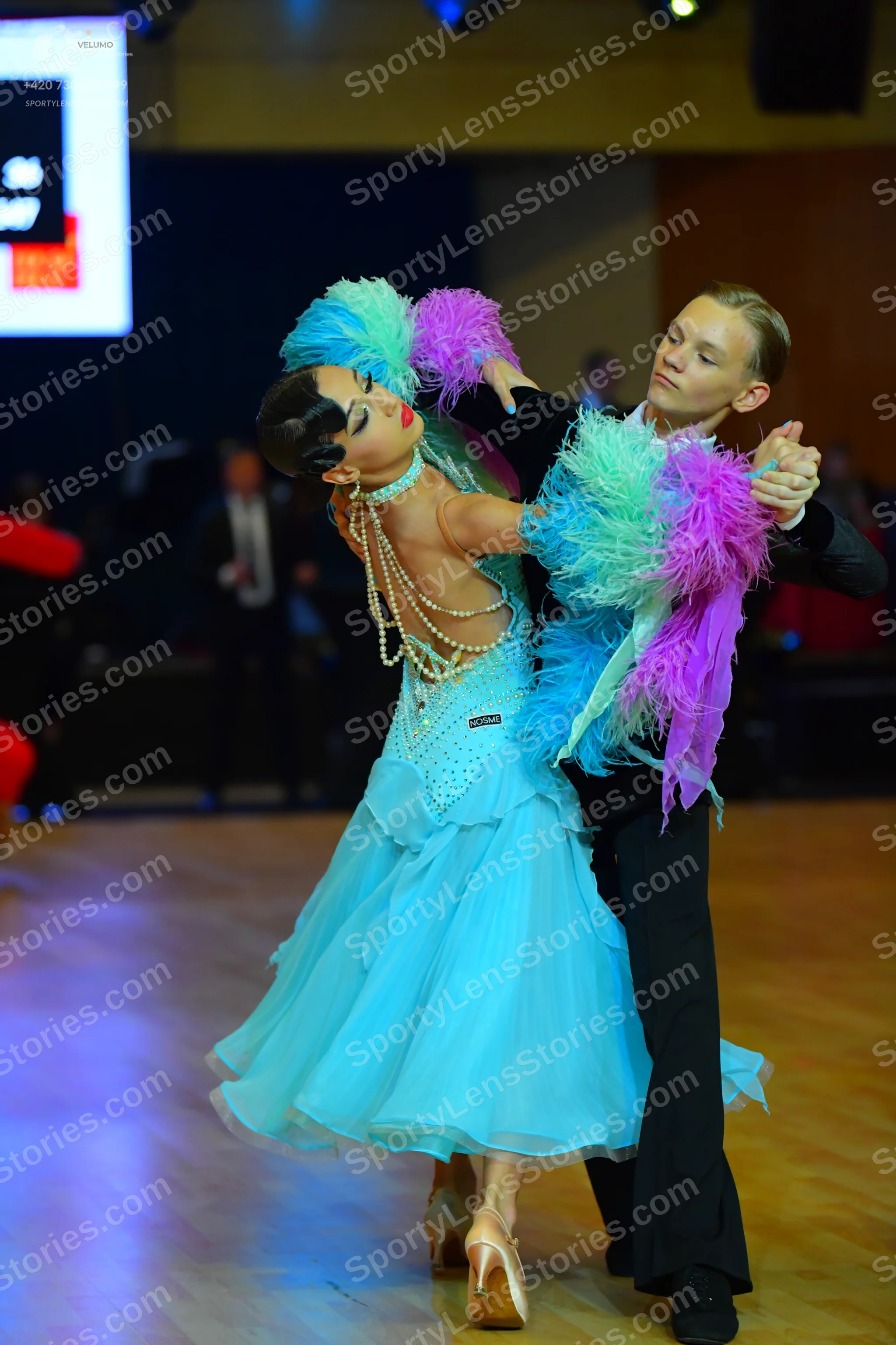 Dancesport competitor: Female dancer: light blue ballroom dress with a layered tulle skirt, a sequined