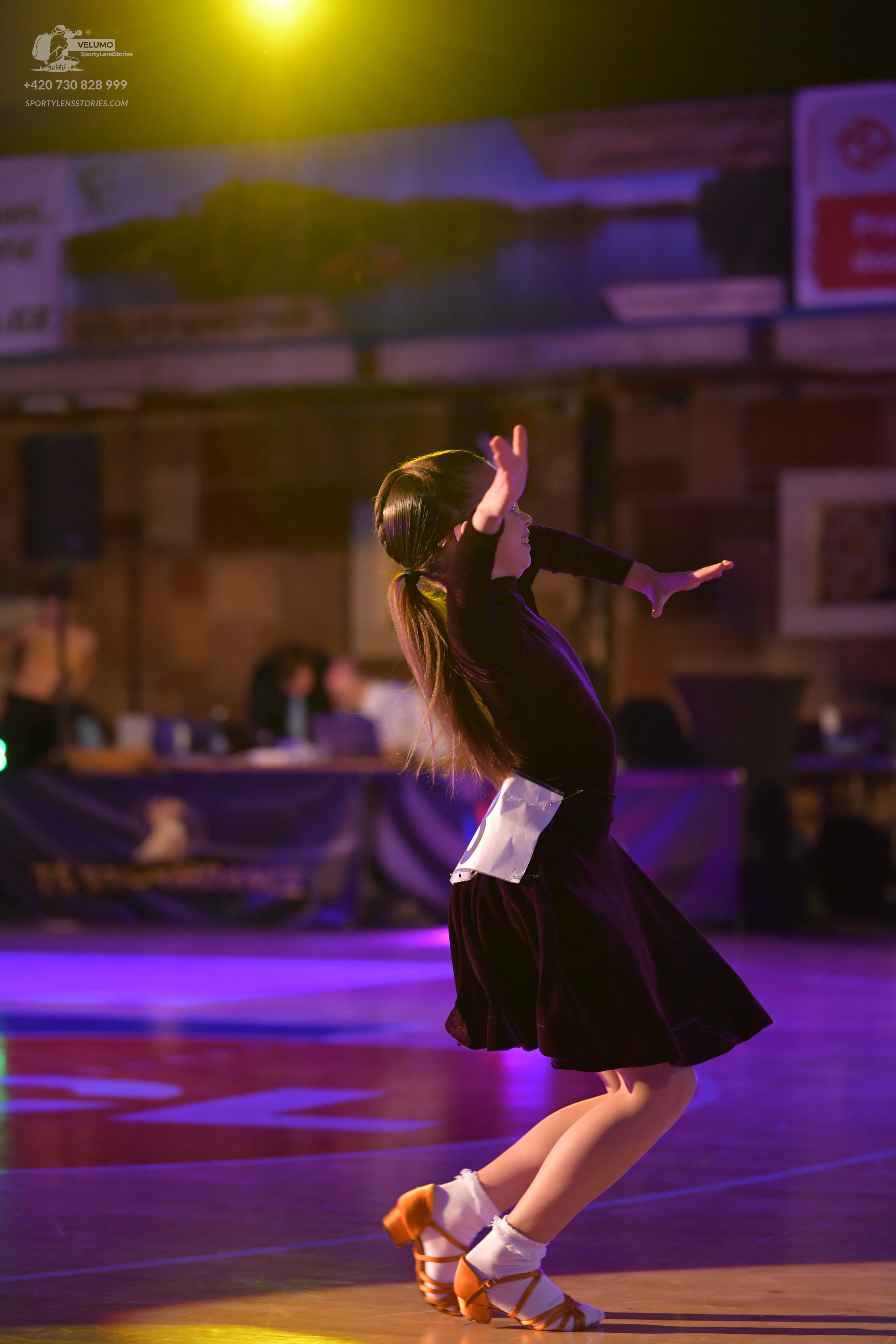 Dancesport competitor: Female dancer: black Latin dress with a white panel on the waist and a flared sk
