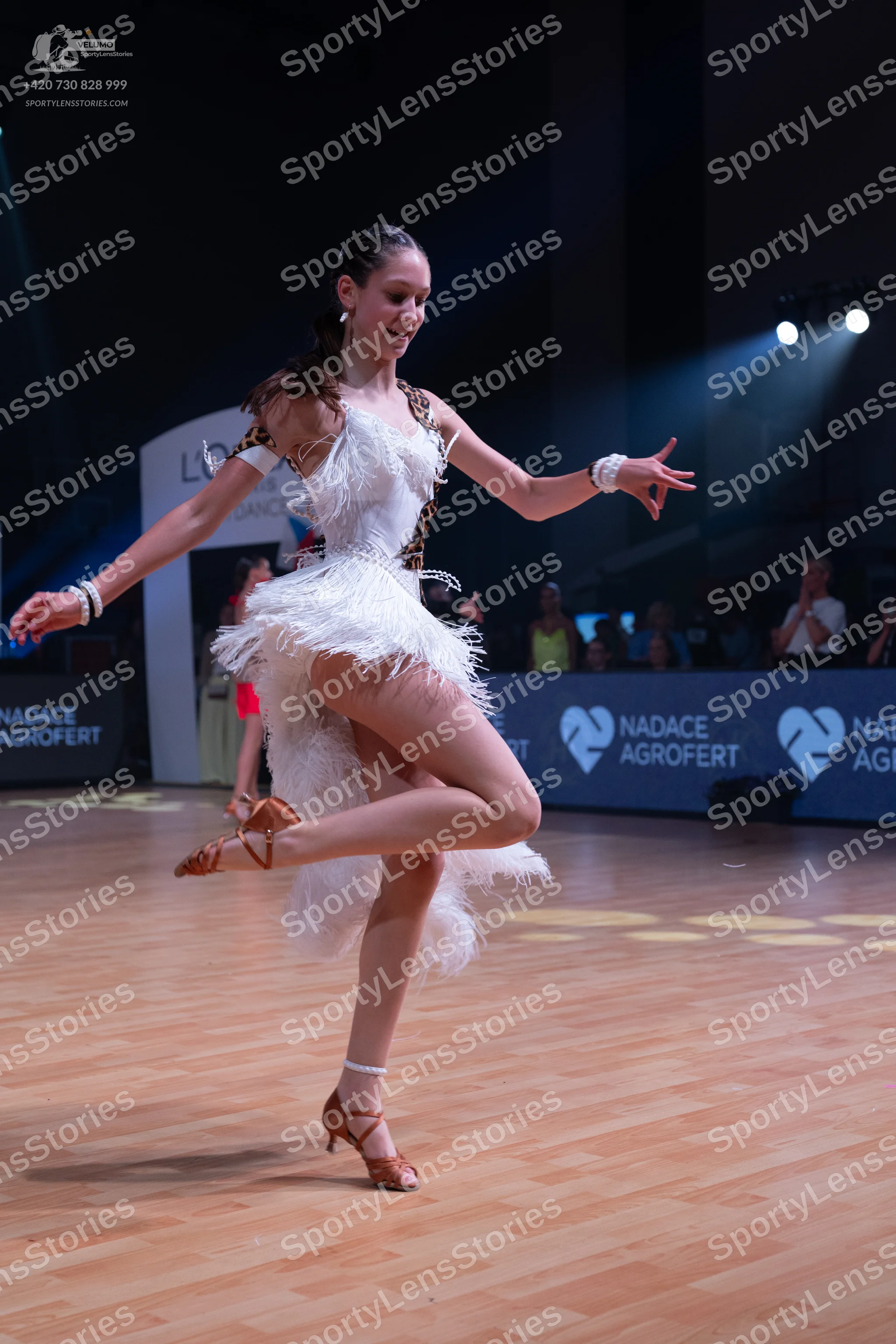 Dancesport competitor: Female dancer: white latin dress with feathery texture and leopard print trim, w