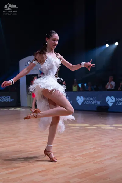 Dancesport competitor: Female dancer: white latin dress with feathery texture and leopard print trim, w