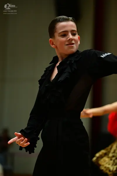 Dancesport competitor: Main dancer: black long-sleeved Latin-style costume with ruffles on the bodice a