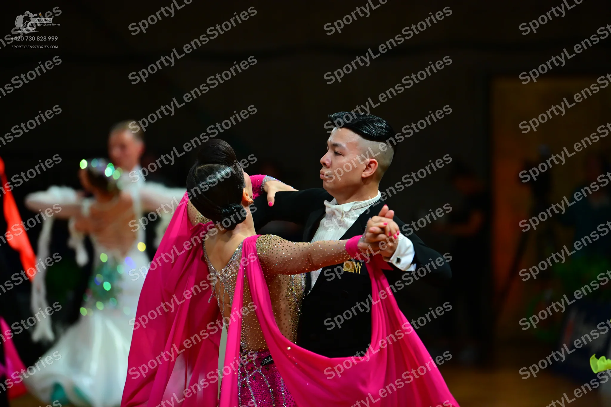 Dancesport competitor: Male dancer in foreground: black suit with a white shirt