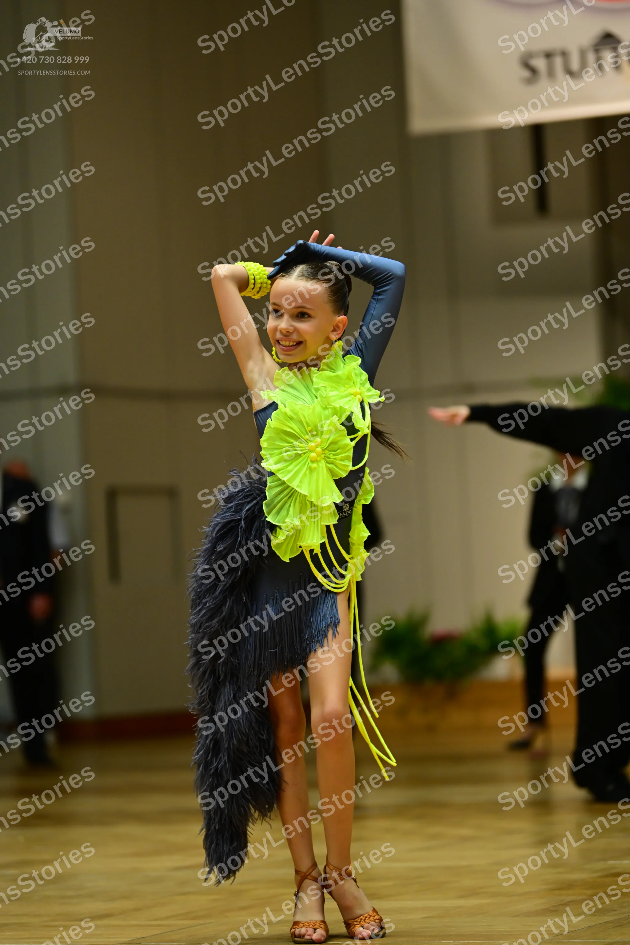 Dancesport competitor: Female dancer: dark navy or charcoal Latin dance dress with a bright lime green
