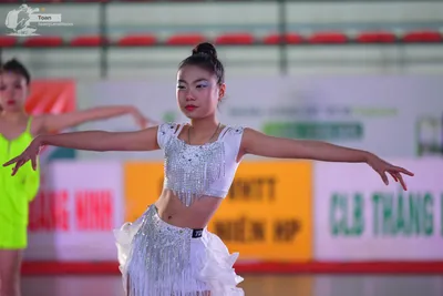Dancesport competitor: ** White, shimmering, halter-style top with a cropped, fringe-trimmed skirt