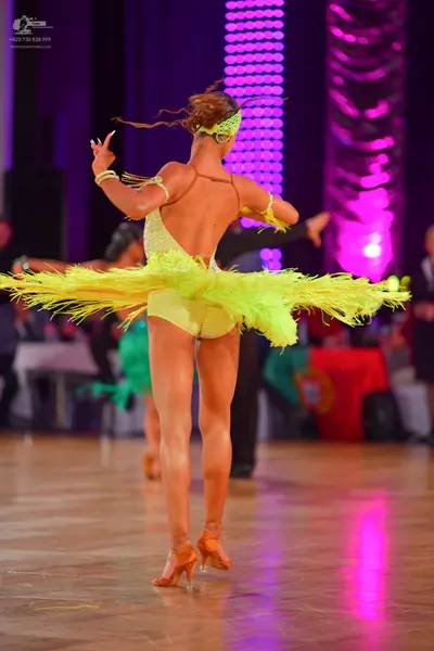 Dancesport competitor: Female dancer: lime green Latin dance costume with a shimmering bodice and a vol